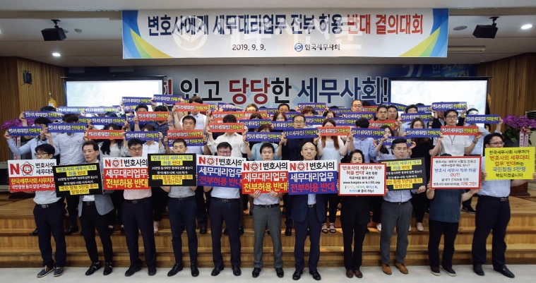 한국세무사회 사무처 직원들이 세무사회관 대강당에 모여 ‘변호사에게 세무대리업무 전부허용 반대’ 피켓을 들고 결의문을 낭독하고 있다.